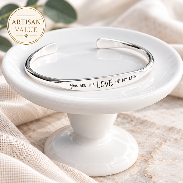 Personalized sterling silver cuff bracelet engraved with a handwritten message, stacked with artisan silver bracelets on a wrist.